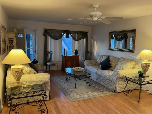 living room featuring ceiling fan and hardwood / wood-style floors