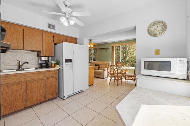 kitchen featuring white appliances, light tile patterned floors, visible vents, and light countertops