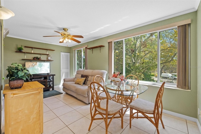 dining space with a ceiling fan, crown molding, baseboards, and light tile patterned floors