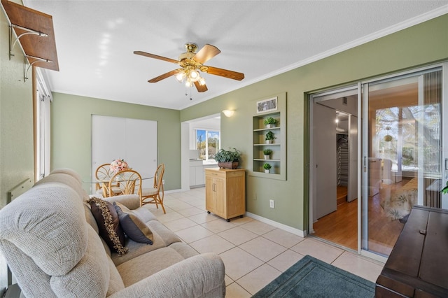 living room featuring light tile patterned floors, baseboards, built in features, ceiling fan, and ornamental molding