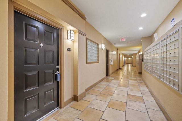 hallway featuring light tile patterned floors, mail area, baseboards, and recessed lighting