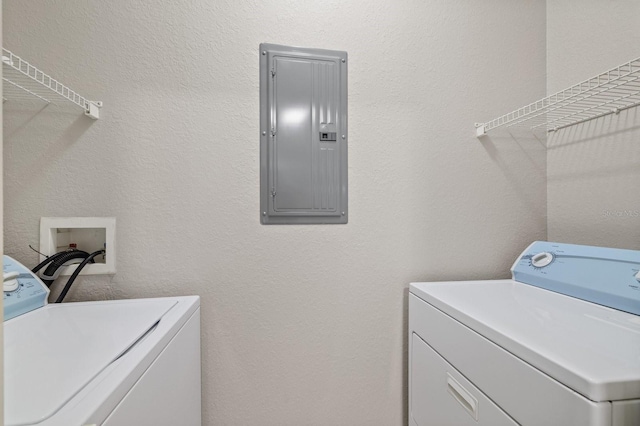 laundry area with laundry area, electric panel, a textured wall, and washing machine and clothes dryer