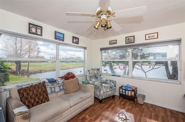 sunroom featuring a water view and ceiling fan