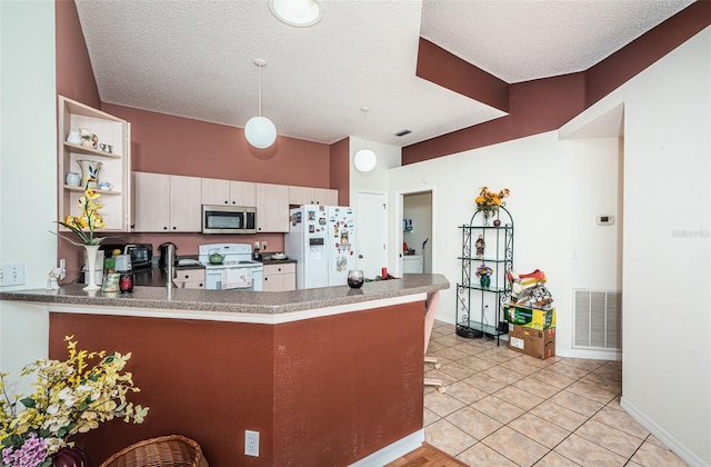 kitchen with kitchen peninsula, white appliances, white cabinetry, and light tile patterned flooring