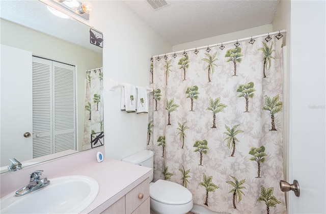 bathroom with vanity, a textured ceiling, and toilet