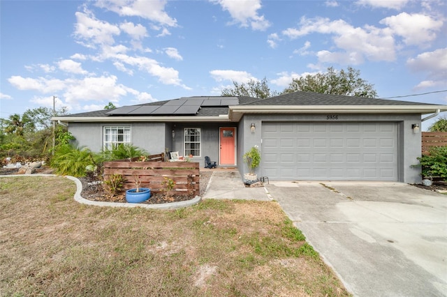 single story home featuring solar panels and a garage