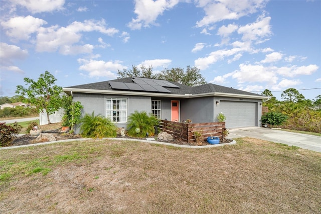 ranch-style home with a garage and solar panels