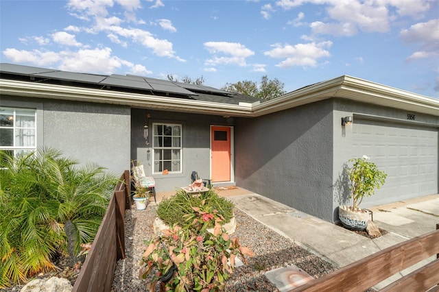 property entrance with solar panels and a garage