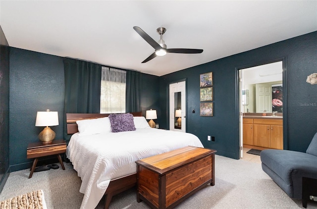 carpeted bedroom featuring ensuite bathroom, sink, and ceiling fan