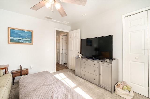 bedroom featuring ceiling fan, a closet, and light colored carpet