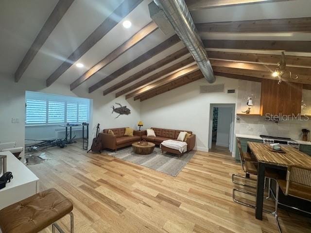 living room featuring lofted ceiling with beams and light wood-type flooring