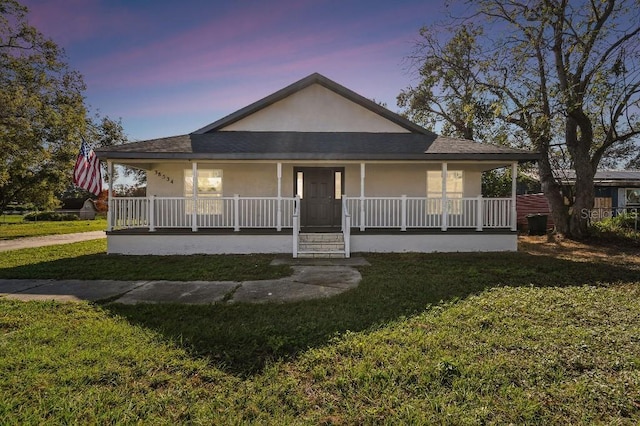 view of front of property featuring a yard and covered porch