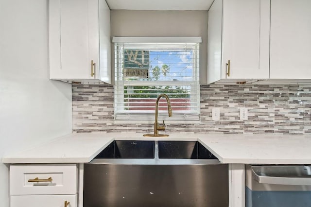 kitchen with decorative backsplash, dishwasher, white cabinets, and sink