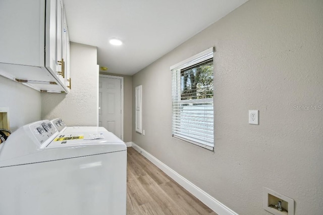 laundry area featuring cabinets, independent washer and dryer, and light hardwood / wood-style floors