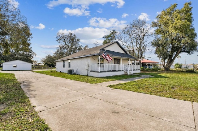 view of front of house with an outdoor structure, central AC unit, a front yard, a porch, and a garage