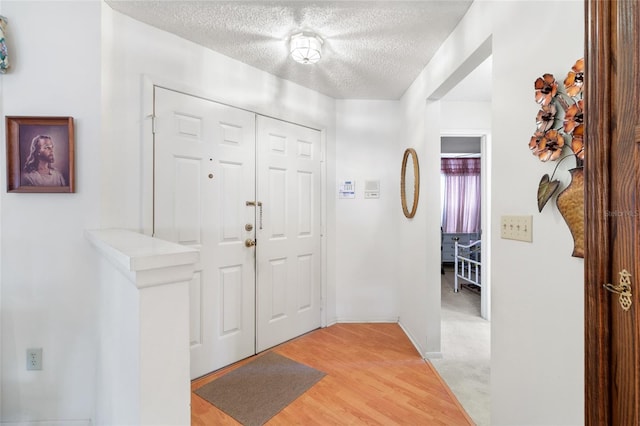 entrance foyer with hardwood / wood-style floors and a textured ceiling