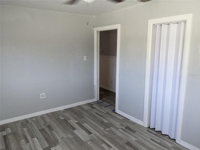 spare room with ceiling fan and wood-type flooring