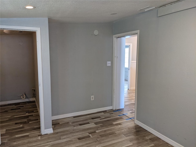 unfurnished room featuring a textured ceiling and hardwood / wood-style flooring