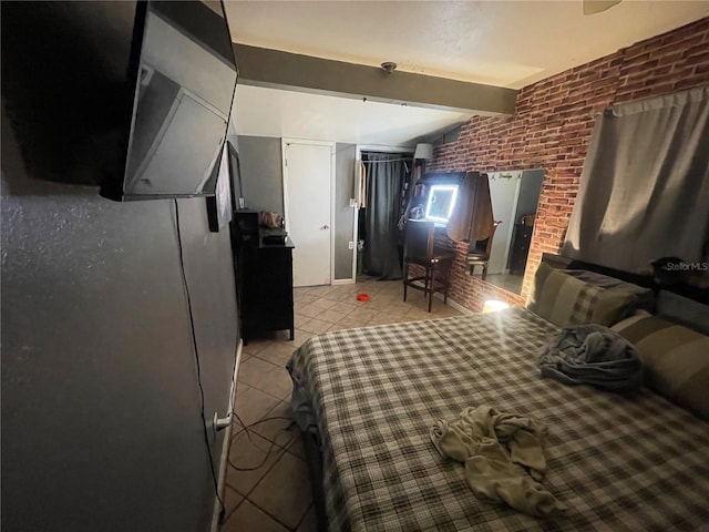 bedroom with beam ceiling, light tile patterned floors, and brick wall