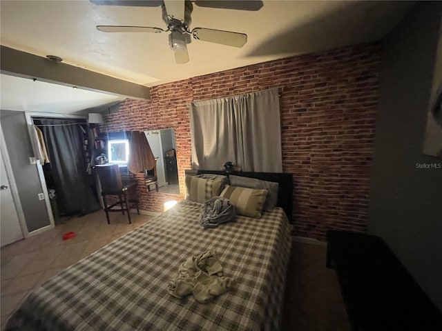 tiled bedroom with beam ceiling, ceiling fan, and brick wall