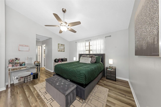 bedroom with hardwood / wood-style flooring, vaulted ceiling, and ceiling fan