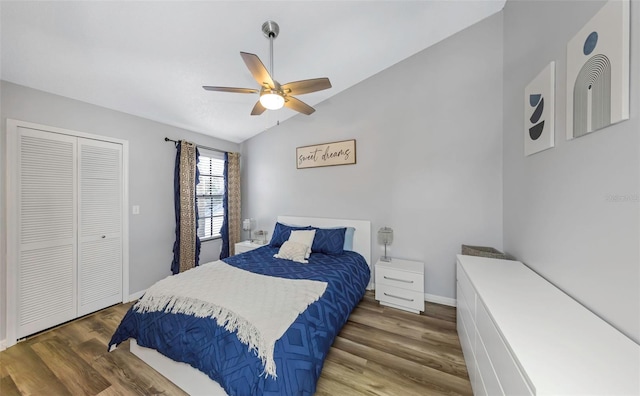 bedroom featuring lofted ceiling, a closet, a ceiling fan, wood finished floors, and baseboards