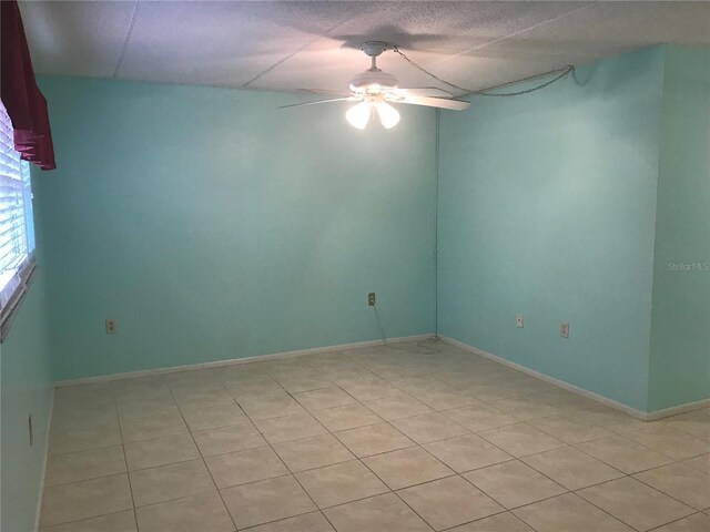 empty room featuring ceiling fan and light tile patterned flooring