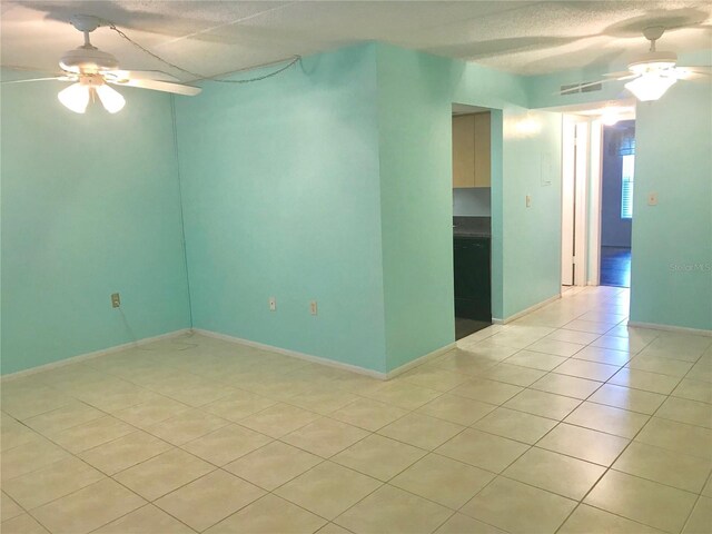 tiled empty room featuring ceiling fan