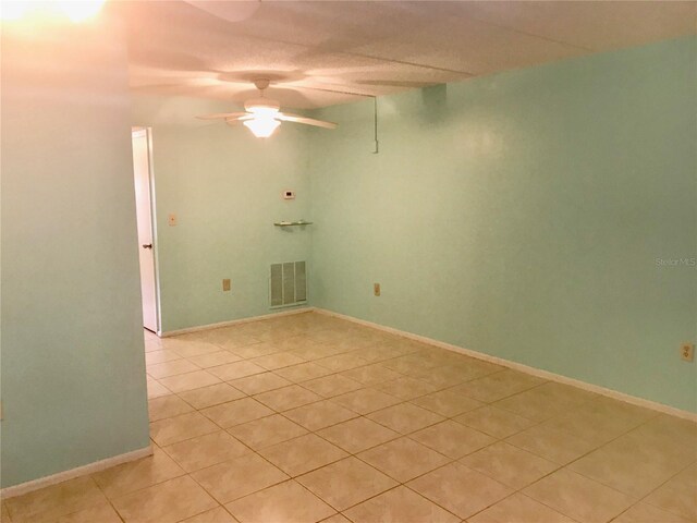 tiled empty room with ceiling fan