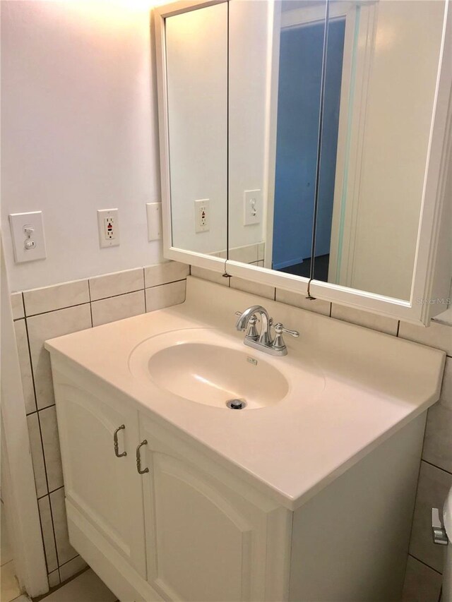 bathroom with vanity and tile walls