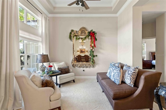 sitting room featuring a tray ceiling, ceiling fan, carpet, and a healthy amount of sunlight