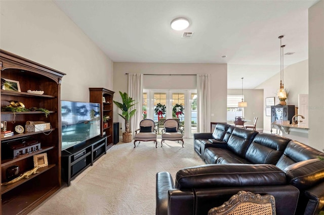 living room featuring french doors, light colored carpet, and vaulted ceiling