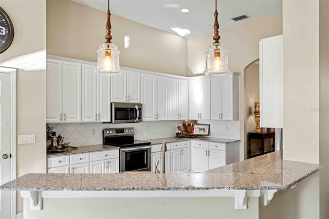 kitchen with white cabinets, appliances with stainless steel finishes, tasteful backsplash, decorative light fixtures, and kitchen peninsula