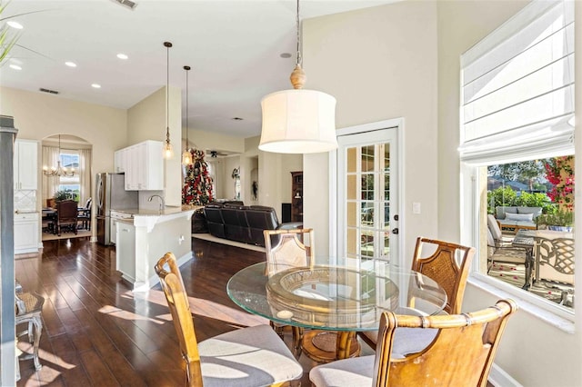 dining room with an inviting chandelier and dark wood-type flooring