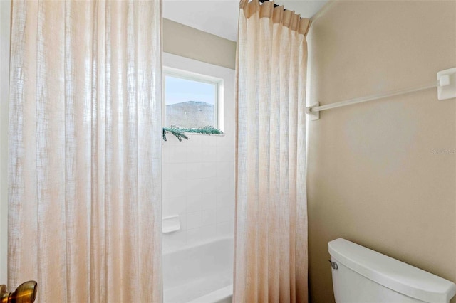 bathroom featuring toilet and shower / bath combo with shower curtain