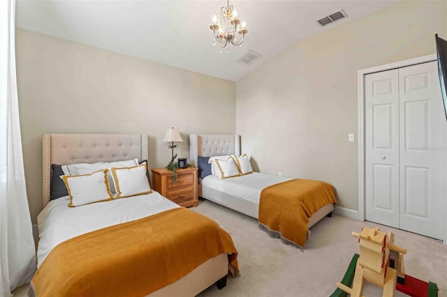 bedroom with a closet, light colored carpet, and an inviting chandelier