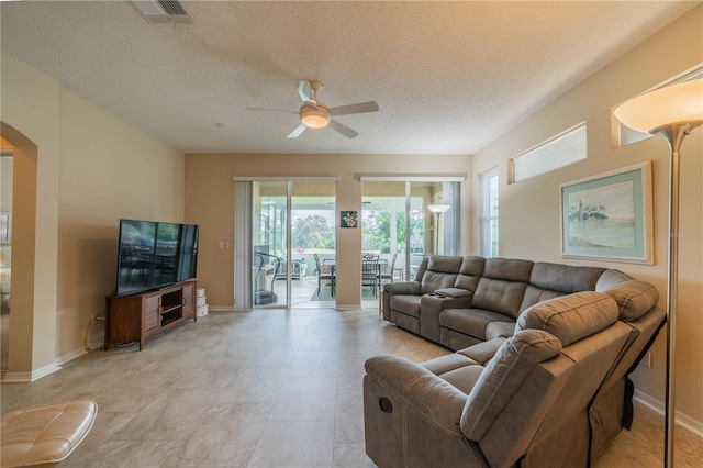 living room featuring a textured ceiling, plenty of natural light, and ceiling fan