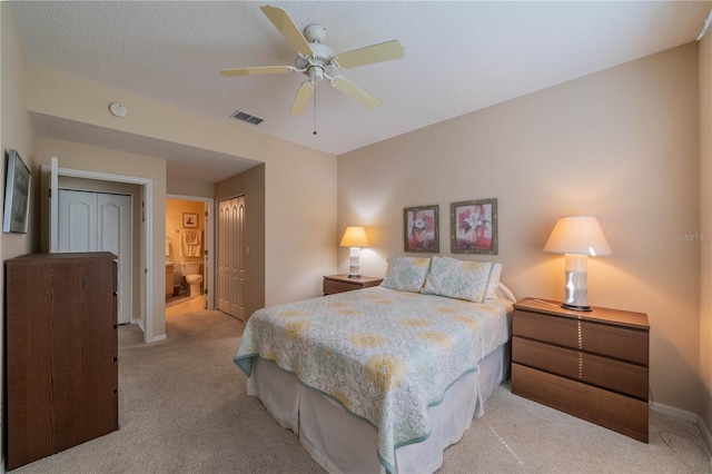 bedroom with light carpet, ensuite bath, and ceiling fan