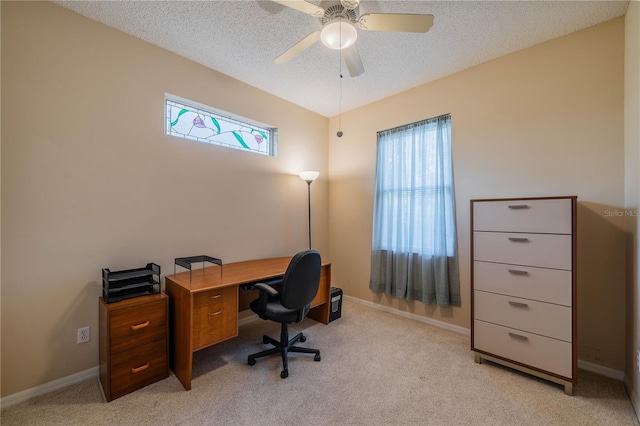 carpeted home office with ceiling fan and a textured ceiling