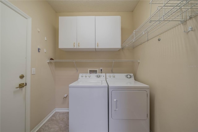 laundry area with washing machine and dryer and cabinets