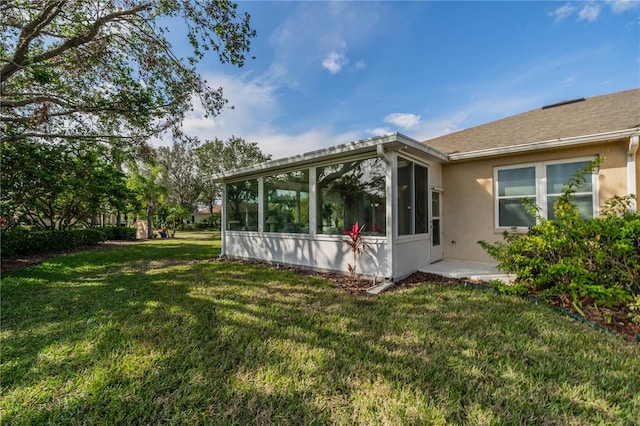 back of house featuring a lawn and a sunroom