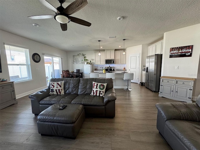 living room featuring ceiling fan, a textured ceiling, and hardwood / wood-style flooring