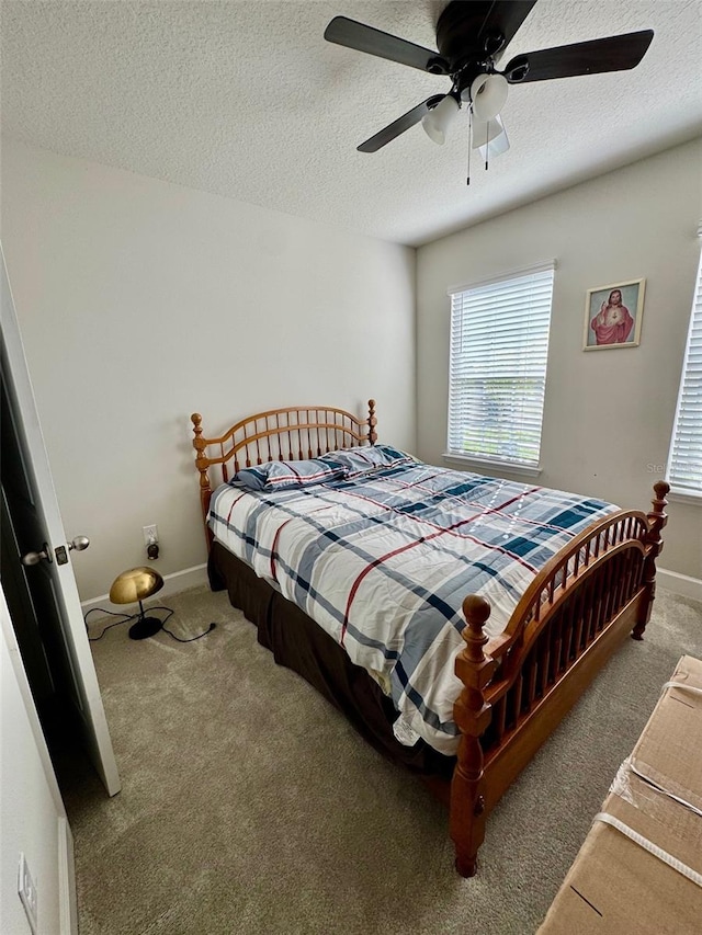 carpeted bedroom featuring a textured ceiling and ceiling fan