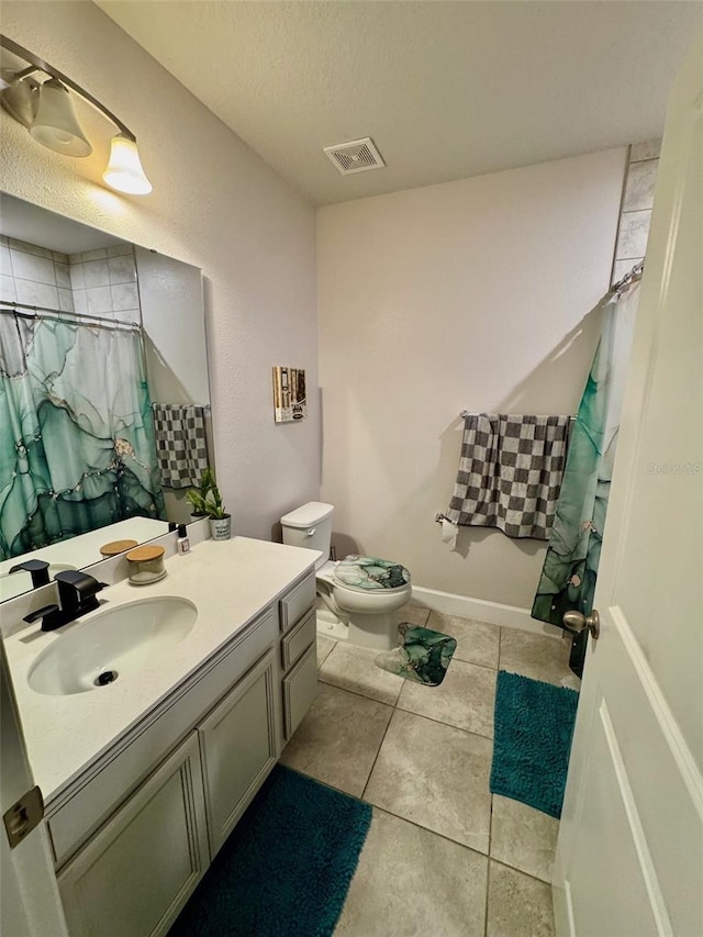 bathroom with tile patterned floors, walk in shower, vanity, a textured ceiling, and toilet