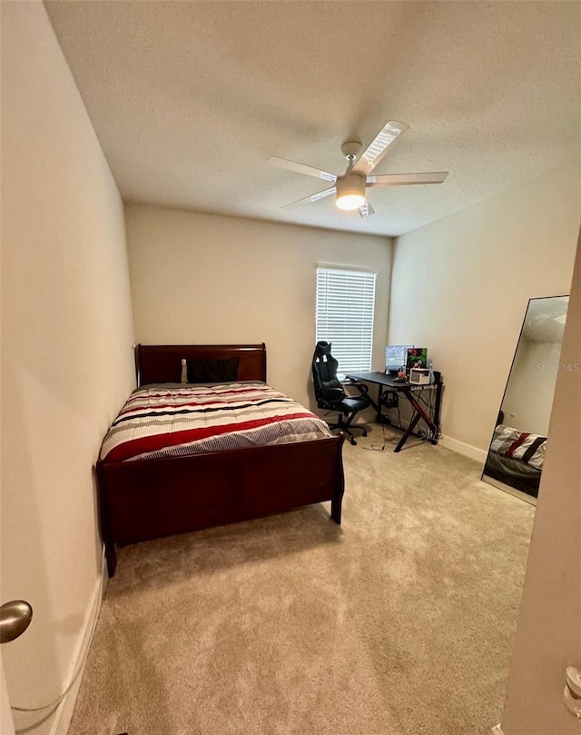 carpeted bedroom with a textured ceiling and ceiling fan