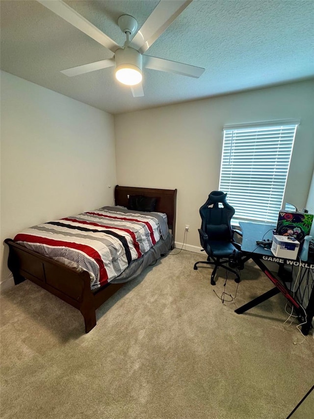 bedroom featuring ceiling fan, light colored carpet, and a textured ceiling