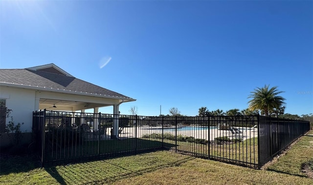 view of yard featuring a patio, a fenced in pool, and ceiling fan