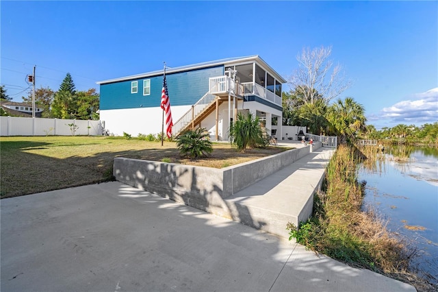 exterior space featuring a lawn and a water view