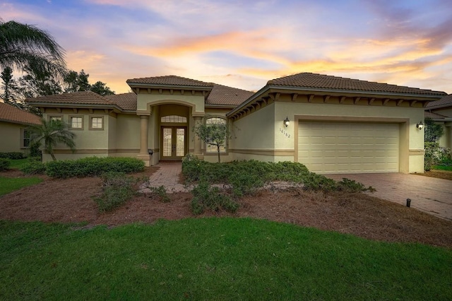 mediterranean / spanish-style home featuring french doors and a garage