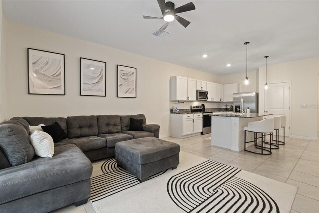 living room with ceiling fan and light tile patterned floors